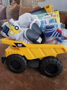 a yellow toy dump truck filled with toys