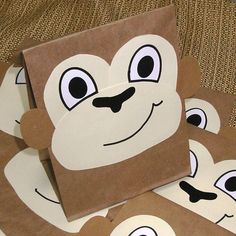 some brown and white monkey themed paper bags on a couch with the faces of three monkeys