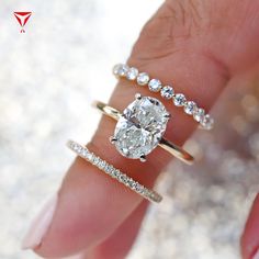 a woman's hand with three different rings on her fingers and one diamond ring in the middle