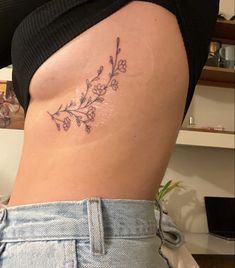 a woman's lower back tattoo with flowers on her stomach and the bottom part of her body