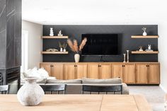 a living room filled with furniture and a flat screen tv on top of a wooden entertainment center