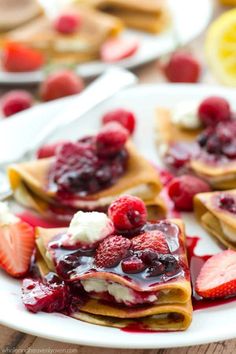 crepes with strawberries and whipped cream on them are ready to be eaten