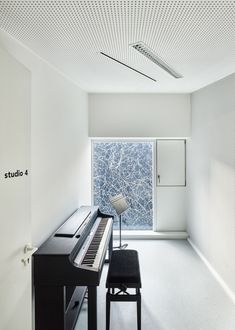 an empty room with a piano and stool