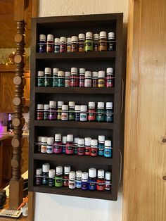 a wooden shelf filled with lots of different types of medicine bottles on top of it