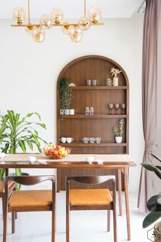 a dining room table with chairs and a shelf filled with fruit on top of it