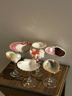 some wine glasses are sitting on a table with seashells and shells in them