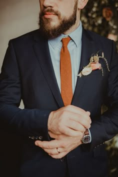 a man in a suit and orange tie