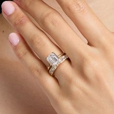 a woman's hand with a diamond ring on top of her finger and an engagement band