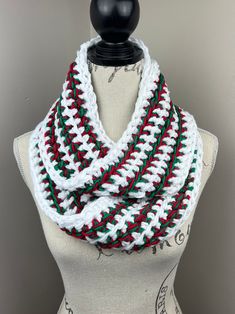 a white and red crocheted scarf on top of a mannequin