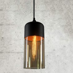 a black and orange light hanging from a ceiling fixture in a room with concrete walls