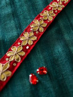 a red and gold ribbon with sequins on it