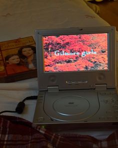 an old laptop computer sitting on top of a bed