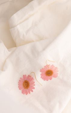 "DESCRIPTION: -Real pressed daisy preserved in resin on gold-filled wire earrings -Available in pink, yellow, and white MEASUREMENTS: -Approx. 1.25\" daisy charms" Gold Daisy Flower Earrings As Gift, Delicate Pink Birth Flower Earrings, Pink Pressed Flower Drop Earrings, Pink Drop Earrings With Pressed Flowers, Pink Birth Flower Drop Earrings, Gold Daisy-shaped Jewelry For Summer, Gold Daisy Jewelry For Summer, Pink Pressed Flower Earrings For Gift, Pink Flower-shaped Earrings With Pressed Flowers