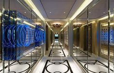 the hallway is lined with mirrored walls and decorative flooring, along with chandeliers