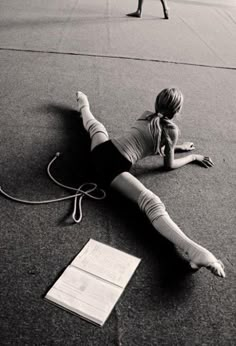 a woman laying on the ground next to a piece of paper and an electric cord