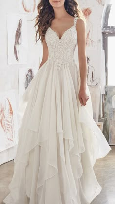 a woman in a white wedding dress is posing for the camera