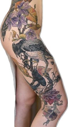 a woman's thigh with tattoos and flowers on her leg, showing the bottom half of