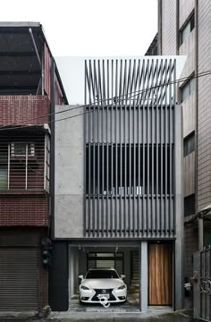 a white car parked in front of a building with metal slats on the side