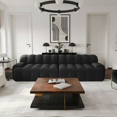 a black and white living room with couches, coffee table, lamps and pictures on the wall