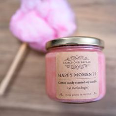 a pink candle sitting on top of a wooden table next to a cotton swab