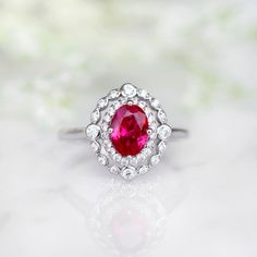 Beautiful Vintage Inspired Ruby Ring Made of Solid Sterling Silver, Rhodium Plated (925) Can be paired with one or two half-eternity Milgrain bands of your choice Accented with Simulated Diamonds (CZ) Center Stone: Ruby Grade: AAA Stone Cut: Oval Gem size: 7.0 x 5.0 mm Carat Weight: 0.76 (approx.) Gemstone creation: 100% Genuine Lab-Grown Ruby Stone Origin: Russia Handling time: 1-2 business days Free domestic shipping. Usually takes 2-5 business days. Wrapped & ready to give in a beautiful Classic Ruby Birthstone Ring With Halo Setting, Anniversary White Gold Ruby Ring With Halo, Silver-toned Ruby Ring With Halo For Wedding, Timeless Ruby Ring With Halo Setting As A Gift, Classic Ruby Ring With Halo Setting For Promise, Classic Sterling Silver Halo Ring For Wedding, Classic Ruby Promise Ring, Classic Halo Ruby Promise Ring, Classic Ruby Promise Ring With Center Stone