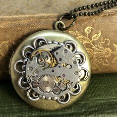 Beautifully detailed swirl round frame highlights this vintage round watch movement. What a great locket to save your favorite photos. Timless and elegant steampunk locket . Fantasy Locket, Elegant Steampunk, Book Locket Necklace, Watch Locket, Moon Goddess Necklace, Filigree Frame, Artisan Jewelry Necklaces, Book Locket, Vintage Timepiece