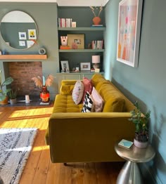 a living room filled with furniture and a fire place under a mirror on the wall