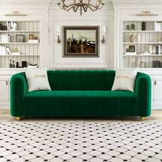 a green couch sitting in front of a white book shelf