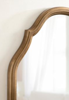 a gold framed mirror against a white wall