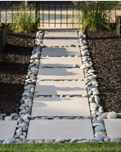 a walkway made out of stones in the grass