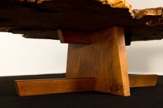 a piece of wood sitting on top of a black tablecloth covered floor next to a white wall