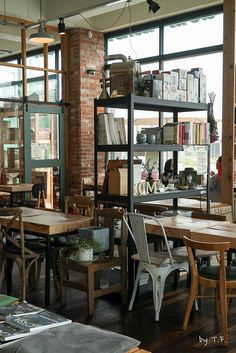 an empty restaurant with tables and chairs in front of large windows that look out onto the street