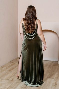 a woman in a green dress is standing on the floor with her back to the camera