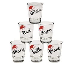 six shot glasses with santa hats and name labels on the bottom, set of four