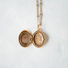 a gold locke necklace with a coin inside