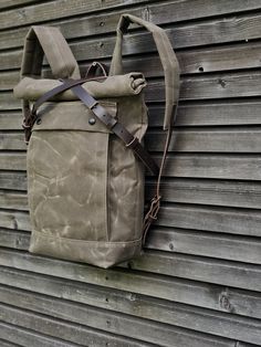 "Backpack in medium size made from waxed canvas in field tan with a volume outside pocket made in waxed canvas. I made it into an everyday backpack/rucksack, with waxed canvas padded straps. Roll to close top, and outside pocket with protective flap. The bottom is made in a double layer of waxed canvas for extra strength and durability . The bag closes with roll to close top and buckle and strap on the front in X-design made from vegetable tanned leather and easy acces on the backside with pouch Rugged Canvas Backpack For Everyday, Outdoor Cotton Backpack With Waxed Finish, Khaki Waxed Canvas Backpack For Outdoor, Rugged Canvas Backpack, Adventure Waxed Canvas Backpack, Rugged Canvas Backpack With Waxed Finish, Rugged Waxed Canvas Backpack, Everyday Leather Backpack With Waxed Canvas Lining, Khaki Waxed Canvas Backpack