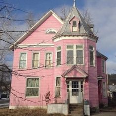 a pink house with white trim and windows