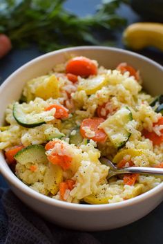 a white bowl filled with rice and veggies on top of a blue table