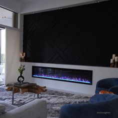 a modern living room with a fireplace in the center and blue flames on the wall