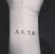 a wrist tattoo with numbers on it that reads 3, 5, 7, 8, 9