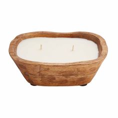 a wooden bowl filled with a white candle