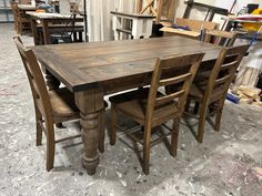 a wooden table with six chairs around it in a room that is being worked on