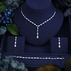 the necklace and earrings are on display next to flowers