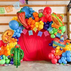 an arrangement of balloons and decorations for a mexican themed birthday party