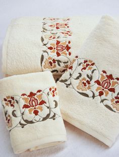 three towels with embroidered flowers on them