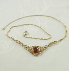 A charming Art Deco gold filled festoon necklace in yellow gold tone. Set to the center with an octagonal cut synthetic citrine tone spinel, 9mm in square, with a mille grain setting. In an ornate patterned mount with plain and patterned entwined scrolls, with a further scroll to each side. On a very fine link chain with a spring ring clasp,  Unmarked. Germany 1930-40. 5.1g   The decorative portion 9cm x 1.8cm.  In inches 3 1/2" x 5/8". 44cm long.  In inches  17 1/4". IN VERY GOOD VINTAGE CONDIT Vintage Yellow Gold Jewelry With Historical Design, Vintage Pendant Necklace With Historical Design, Antique Yellow Gold Necklace With Historical Design, Vintage Necklace With Historical Design For Gift, Vintage 14k Gold Necklace For Formal Occasions, Vintage Hallmarked Wedding Necklaces, Vintage 14k Gold Jewelry With Bail, Vintage 14k Gold Pendant Jewelry, Vintage 14k Gold Oval Necklaces