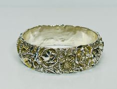 Vintage Repousse Sterling Silver Bangle Stamped 925 Ornate Thick Silver Bangle Up for sale is this gorgeous repousse sterling silver bangle, stamped 925. It is one inch wide, with a circumference measured from the inside of 8 1/2 inches (2 5/8 inches diameter.) Stunning ornate design, some of the flowers have gold gilt to add dimension to the piece. It weighs 33 grams. Very good condition as you can see from the photos. Please see the photos and the video for a more detailed description of this Luxury Ornate Sterling Silver Bangle, Luxury Vintage Filigree Bangle, Ornate Design, Sterling Silver Bangle, Sterling Silver Bangles, Silver Bangle, One Inch, Silver Bangles, The Flowers