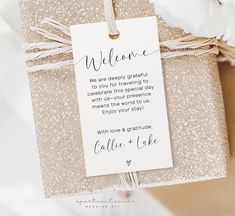 a gift wrapped in glitter paper with a welcome tag