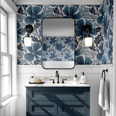 a bathroom with blue and white floral wallpaper, two sinks and a large mirror