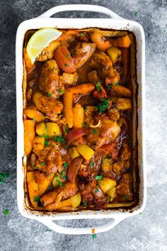 a casserole dish with meat, potatoes and carrots